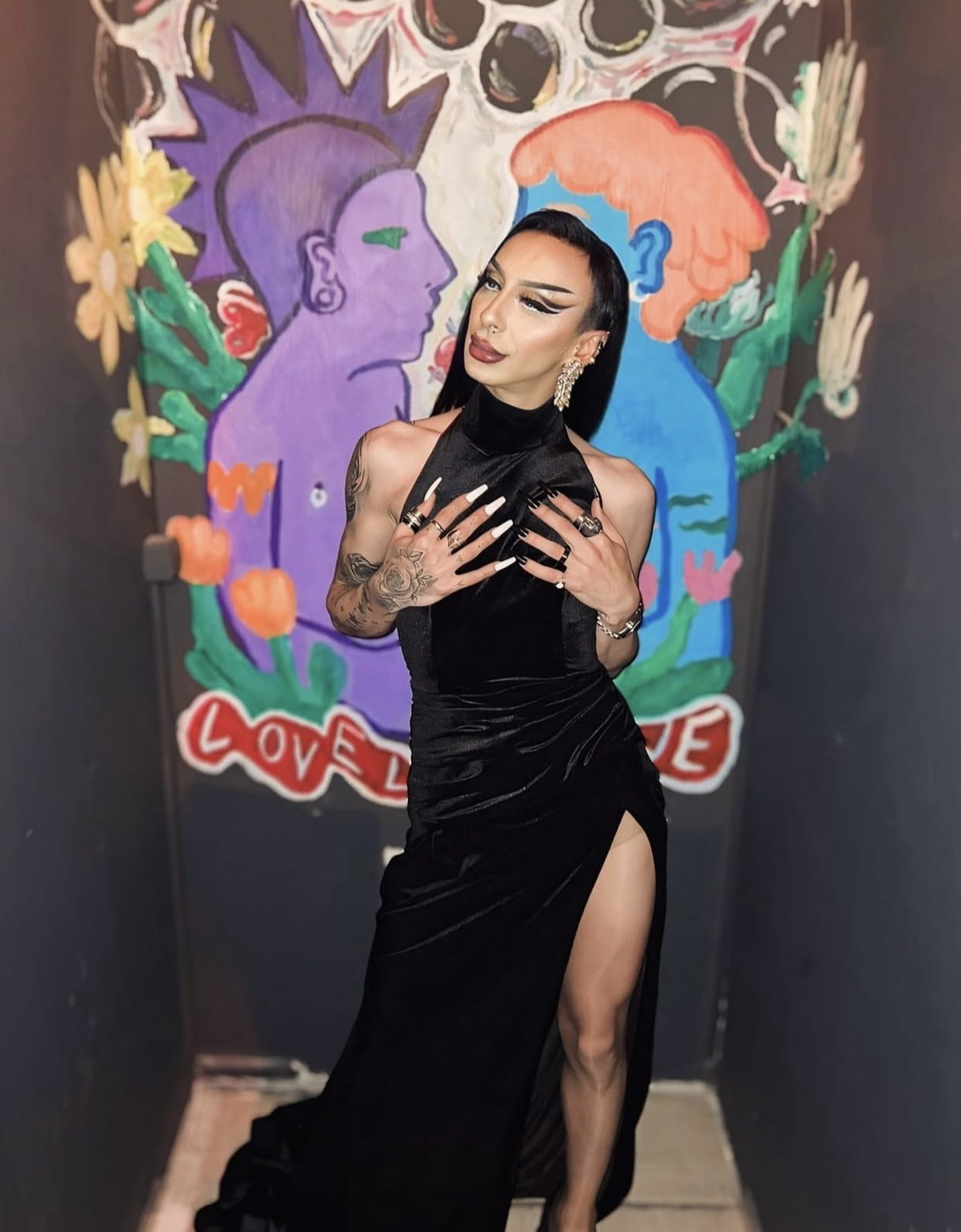 Sa svojom armijom Instagram pratilaca/teljki i spektakularnim talentom, Diva ne treba uvod. On ruši očekivanja kao aktivista, izvođač i makeup umetnik, osvajajući svoje mesto u prištinskoj drag zajednici s nepokolebljivim samopouzdanjem. Po mom mišljenju, mogao bi bez problema da pobedi na RuPaul’s Drag Race, ali je umesto toga pratio svoj san da postane makeup umetnik. Diva koristi svoje znanje, slavu i veze kako bi osnovao Queen’s Corner, salon u srcu grada — izvinjavamo se, RuPaul, ali naša kraljica nema vremena da se takmiči u tvojoj emisiji! <br />
<br />
Diva je počeo lokalnim nastupima, a ubrzo se proširio i na međunarodnu scenu. Važan trenutak u njegovoj karijeri bio je kada se pojavio u spotu za pesmu “Pussypower” nemačke pop zvezde Katje Krasevice.